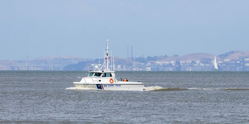 Een witte politieboot vaart over het water tijdens een klopjacht op zee.