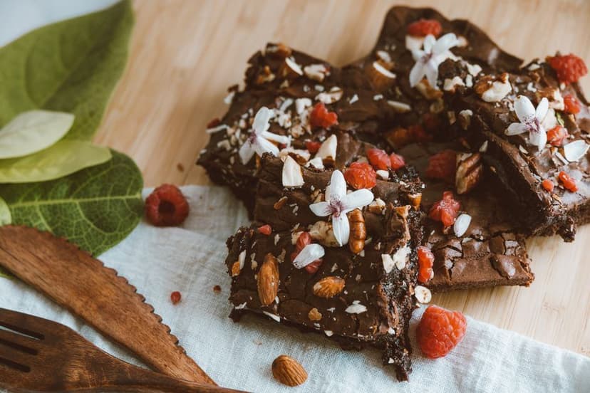 Chocoladebrownies met frambozen, amandelen en bloemetjes, heerlijk als zoete snack voor bij een warme wietthee.