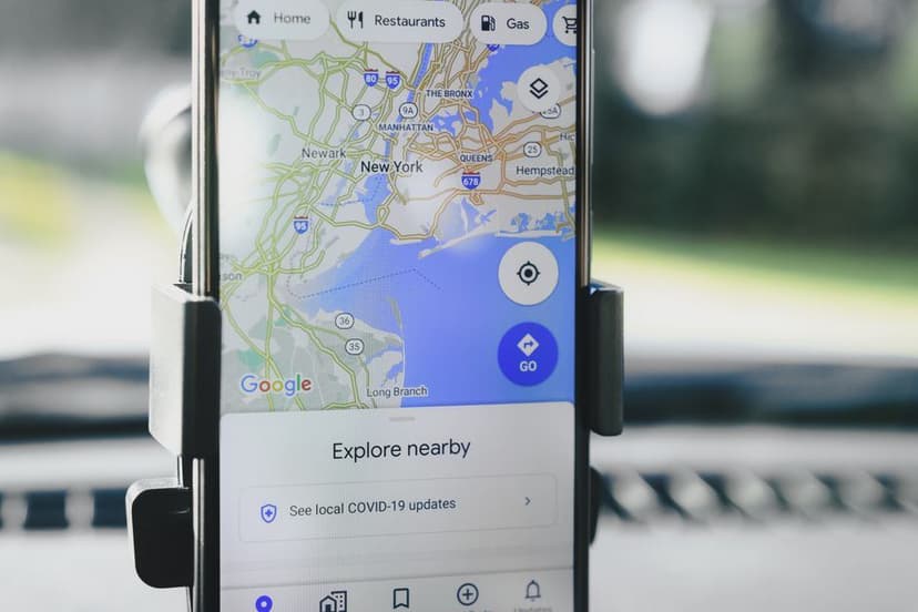 Een smartphone in een autohouder toont Google Maps voor het navigeren en zoeken naar locaties.