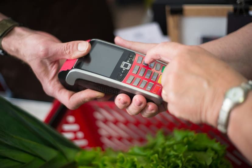 Een klant toetst een pincode in op een mobiele betaalautomaat tijdens een pinbetaling.