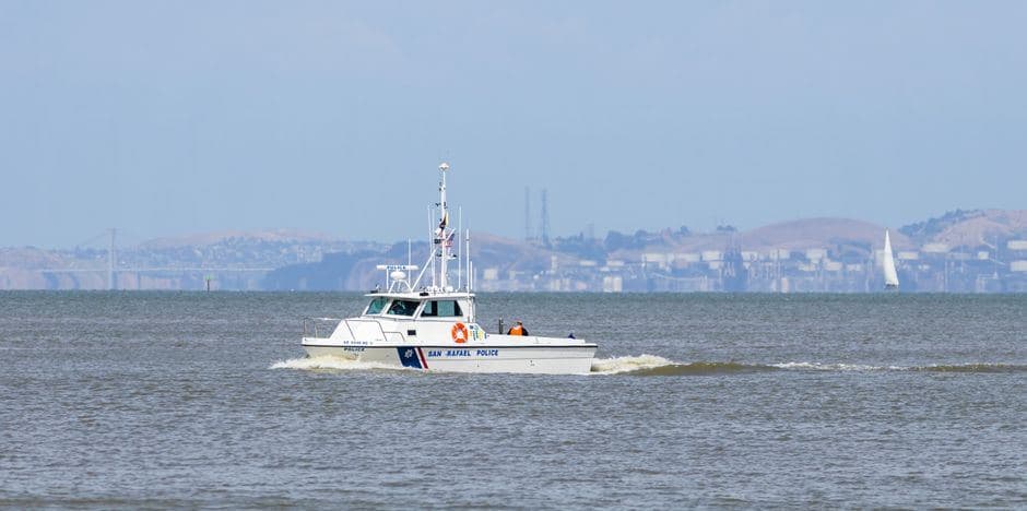 Een witte politieboot vaart over het water tijdens een klopjacht op zee.